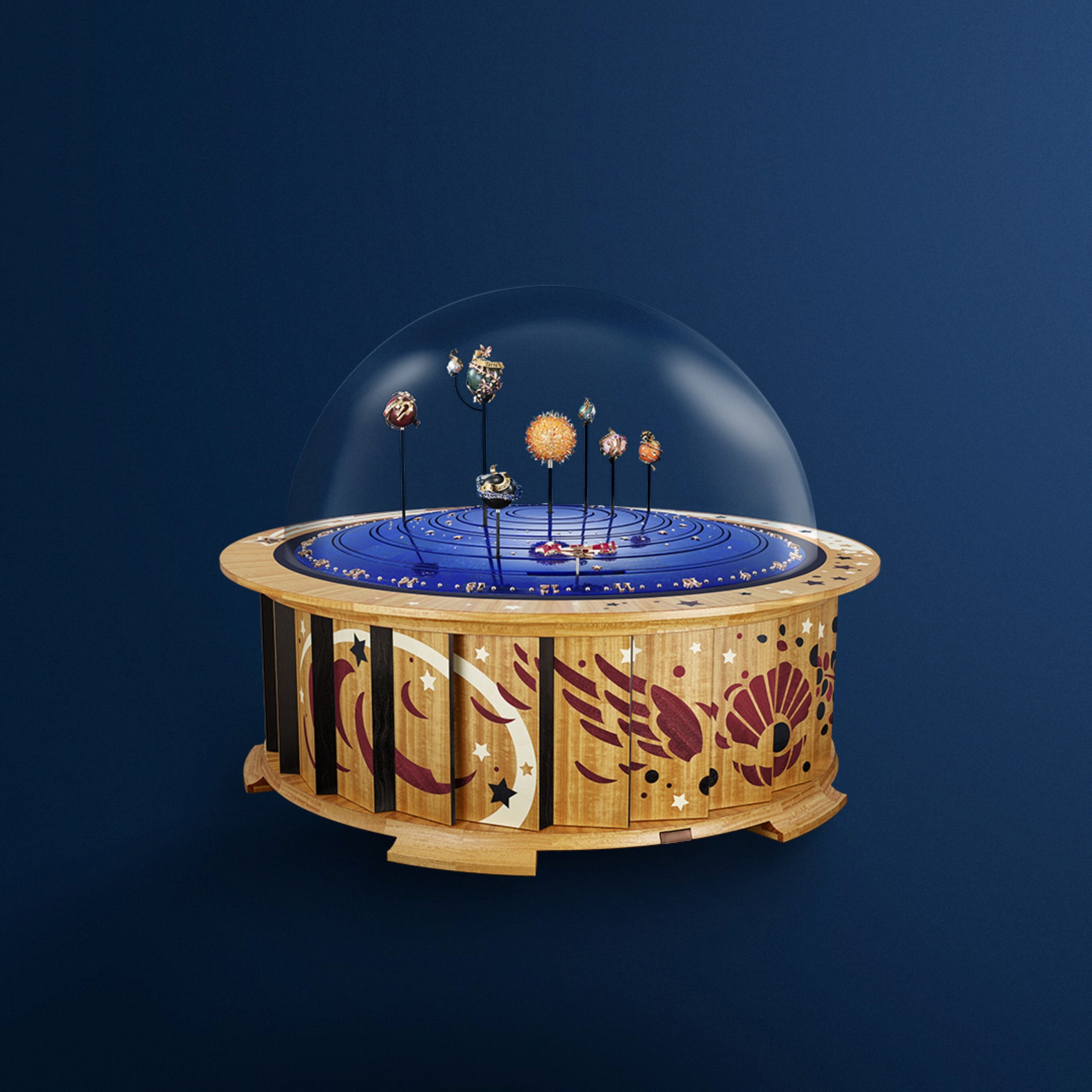 Autómata Planétarium, oro amarillo, blanco y rosa, rubíes Serti Mystérieux Traditionnel™, rubíes, zafiros de color, granates espesartinas, diamantes, lapislázuli, calcedonia, perla, jaspe, azabache, cuarzo rosa lechoso, piedra lunar naranja, limonero, ciricote, amaranto, acebo blanco, cristal, aluminio, acero, latón, PVD, piel. Movimientos autómatas y mecánicos, módulo planetario, calendario perpetuo, esfera de horas/minutos, animación bajo demanda y carillón. Colección Objetos Extraordinarios™, Van Cleef & Arpels.