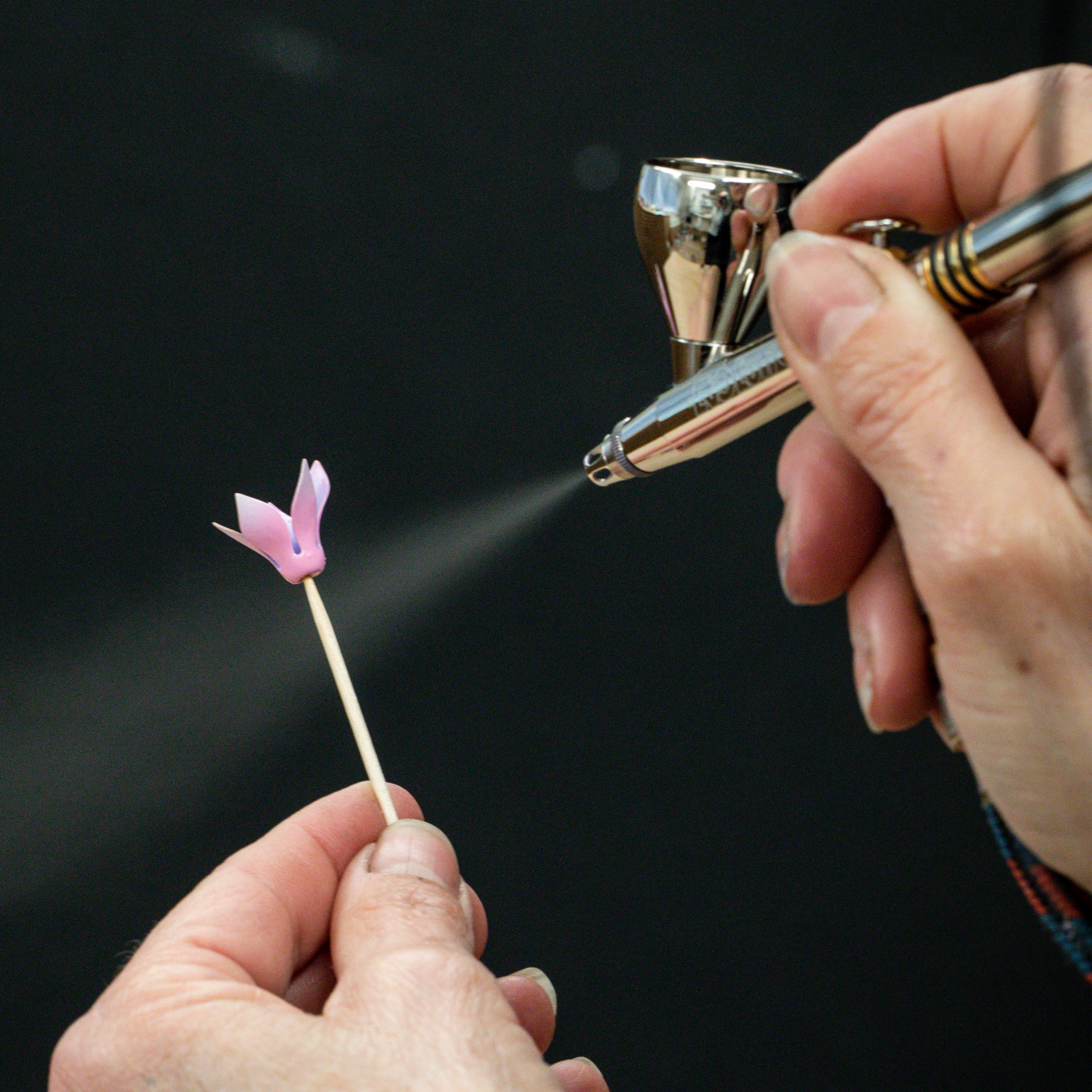 Airbush lacquer application on a rose gold cyclamen flower. Eveil du Cyclamen automaton, Extraordinary objects collection, Van Cleef & Arpels.
