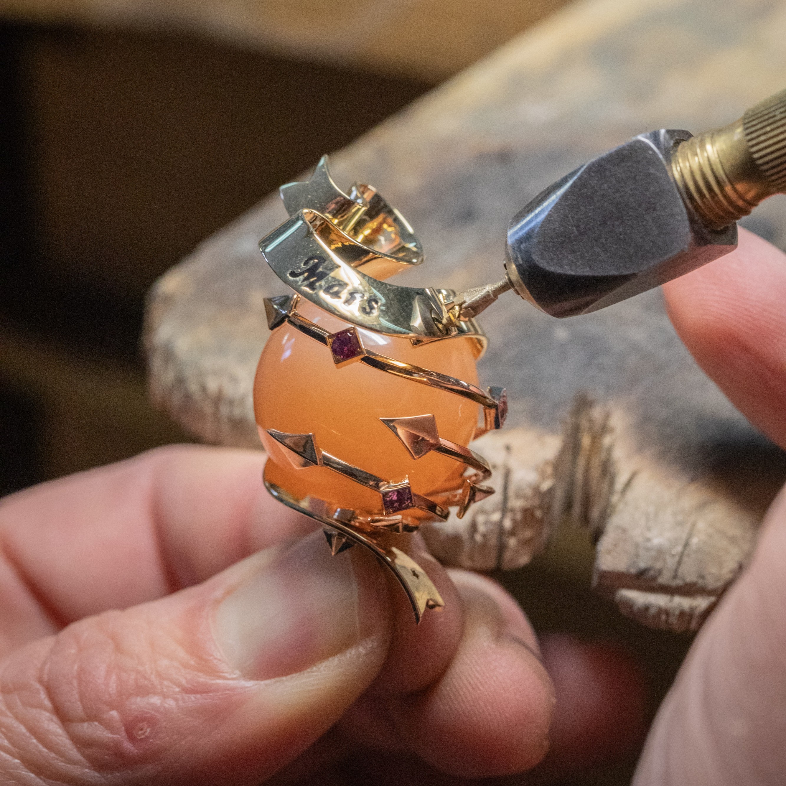Befestigen der Struktur des Mars aus Gelbgold an dem orangefarbenen Mondstein. Sammlung Van Cleef & Arpels.