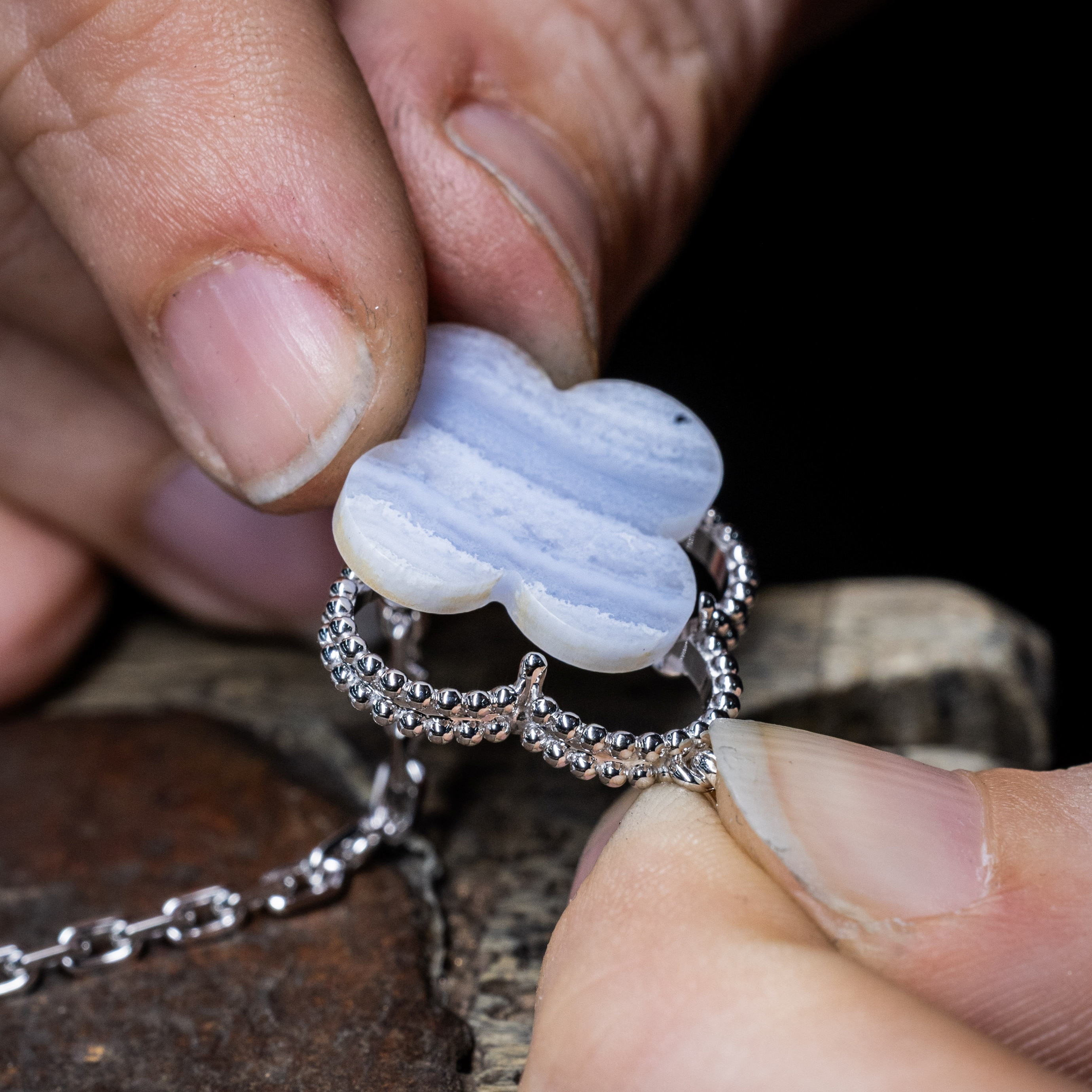 Assembling the gray mother-of pearl motif to the gold structure of the Magic Alhambra transformable long necklace, Van Cleef & Arpels.