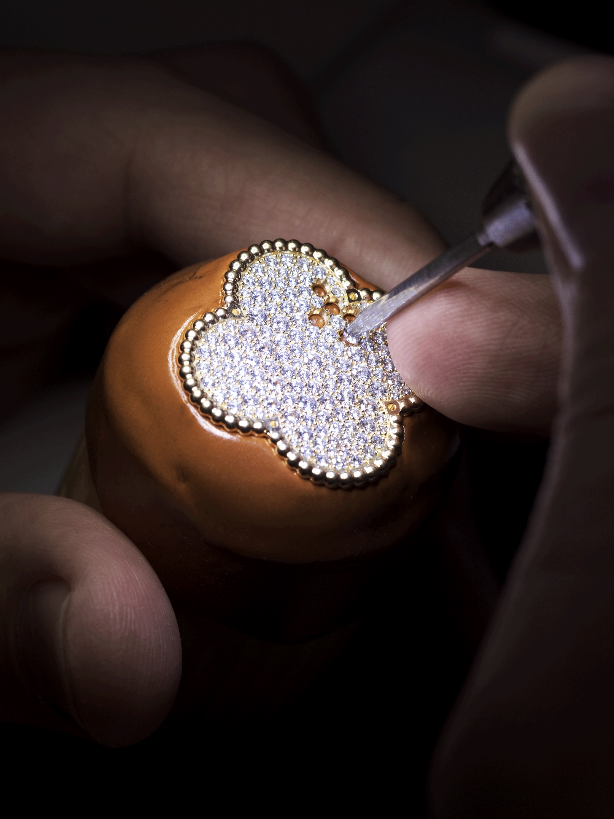 Setting the diamonds on the rotating jewelry motif. Alhambra collection, Van Cleef & Arpels.