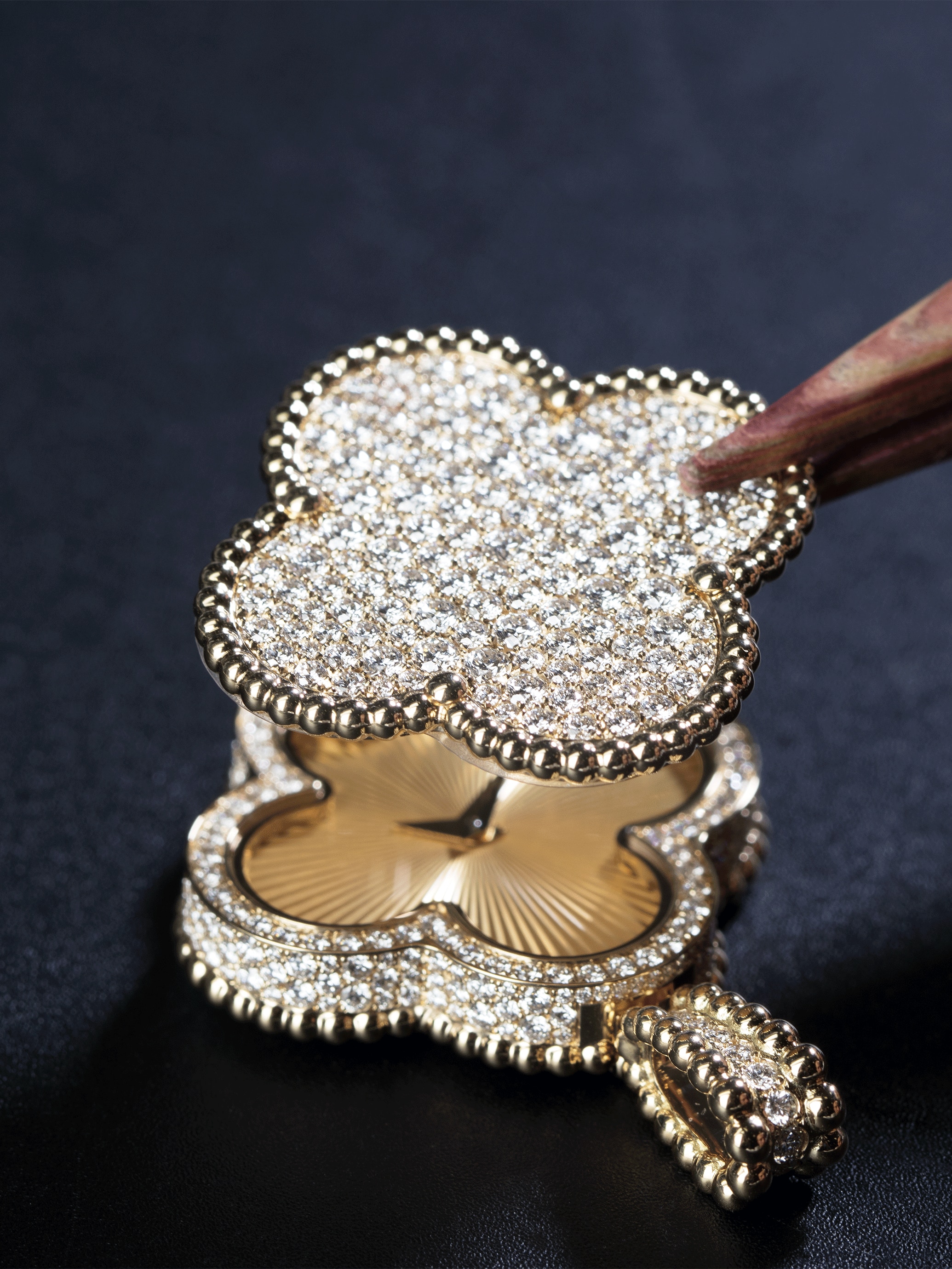 Assembling the rotating jewelry motif onto the case. Alhambra collection, Van Cleef & Arpels.