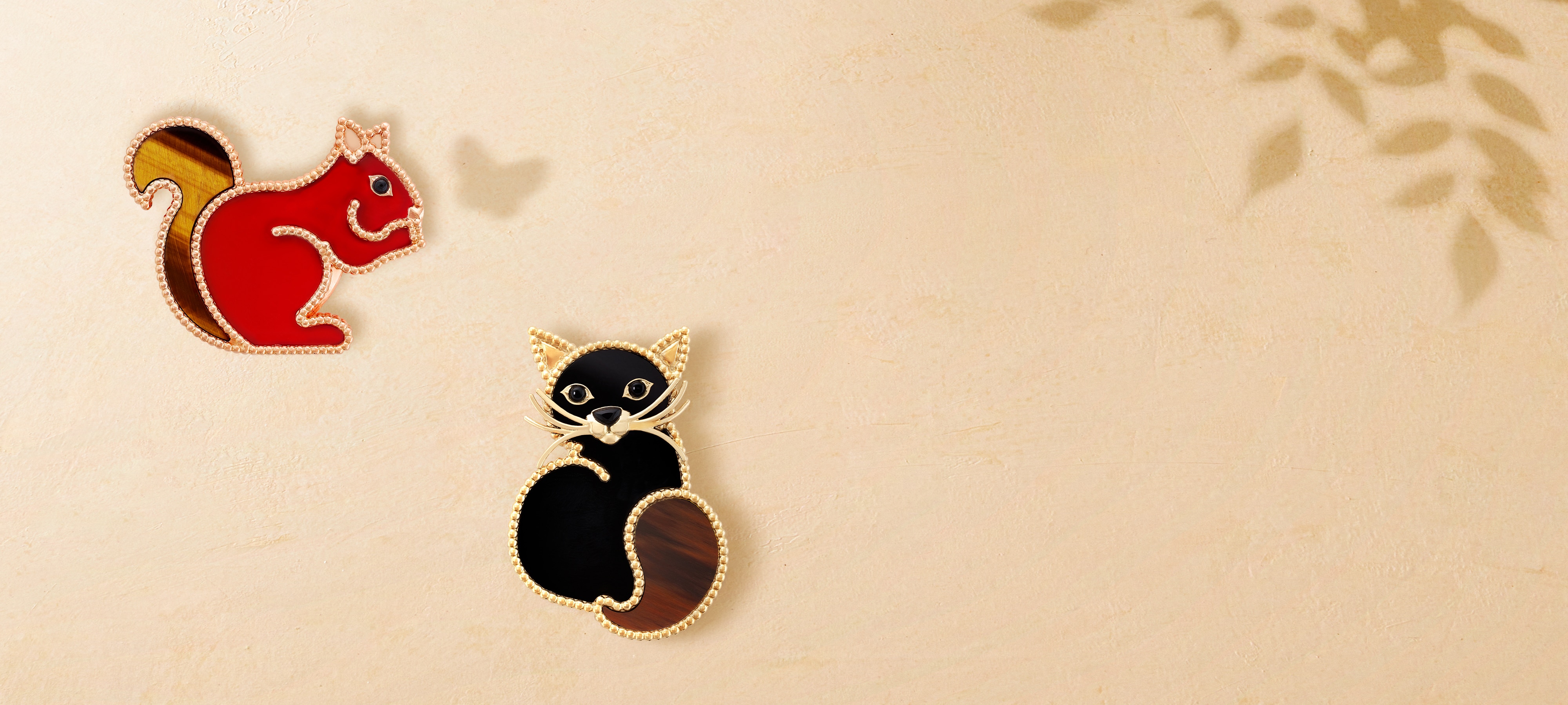 Lucky Animals Squirrel broş, pembe altın, karnelyan, oniks, kaplan gözü. Lucky Animals Cat Broş, sarı altın, obsidiyen, oniks. Lucky Animals koleksiyonu, Van Cleef & Arpels.