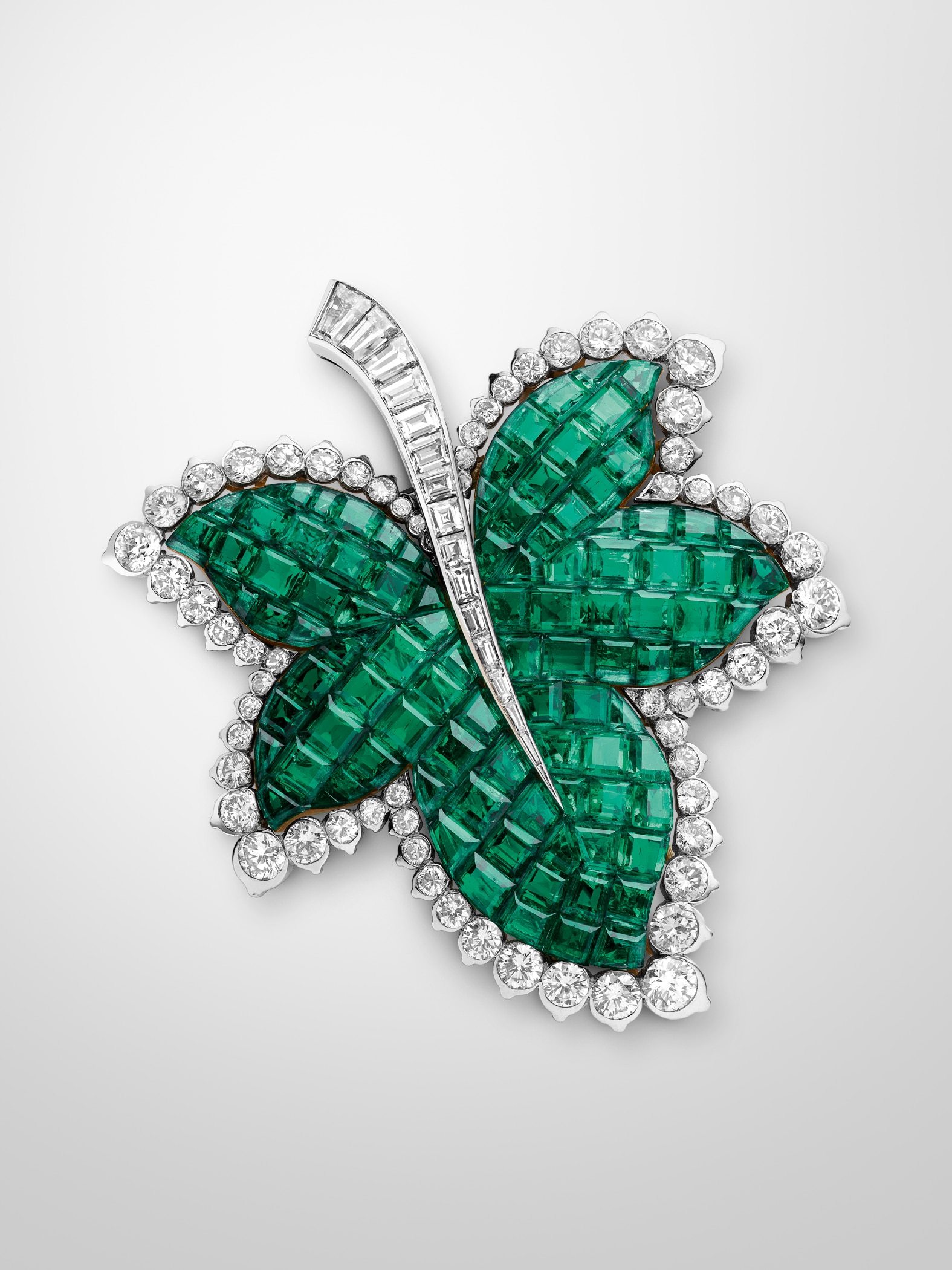 Plane tree leaf clip, 1951, platinum, yellow gold, Mystery Set emeralds, diamonds. Van Cleef & Arpels collection.