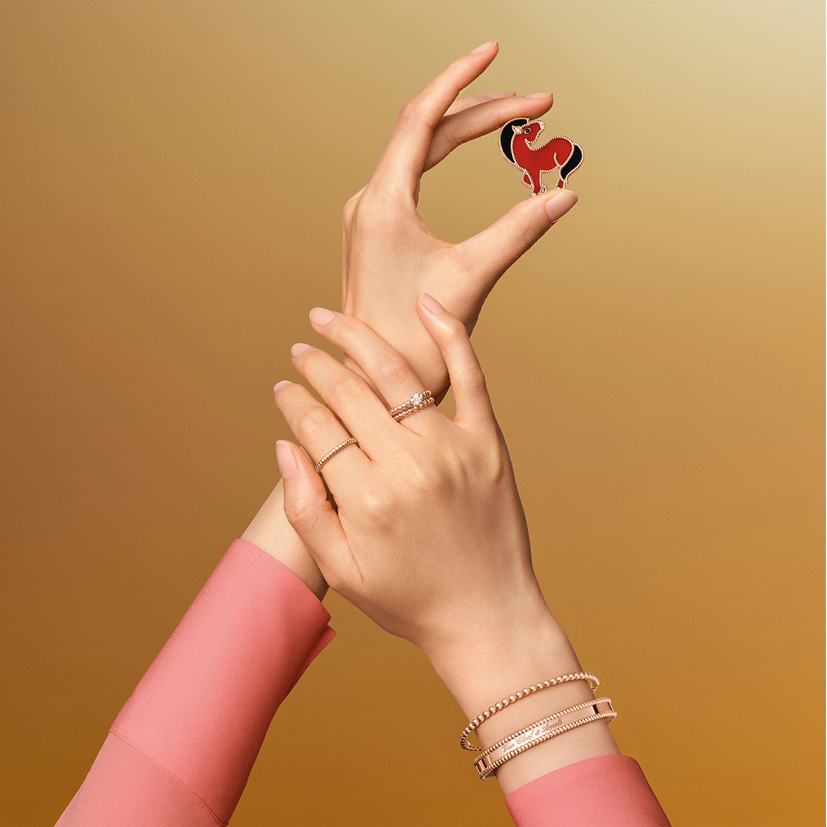 "Lucky Animals Horse clip, 18K rose gold, carnelian, onyx. Lucky Animals® collection, Van Cleef & Arpels. Perlée solitaire, 18K rose gold, one round 0.50 ct EVVS2 diamond. Perlée pearls of gold ring, small model, 18K rose gold. Perlée pearls of gold ring, medium model, 18K rose gold. Perlée pearls of gold bracelet, 18K rose gold, medium model. Bracelet Perlée signature, or rose, moyen modèle. Perlée® collection, Van Cleef & Arpels."
