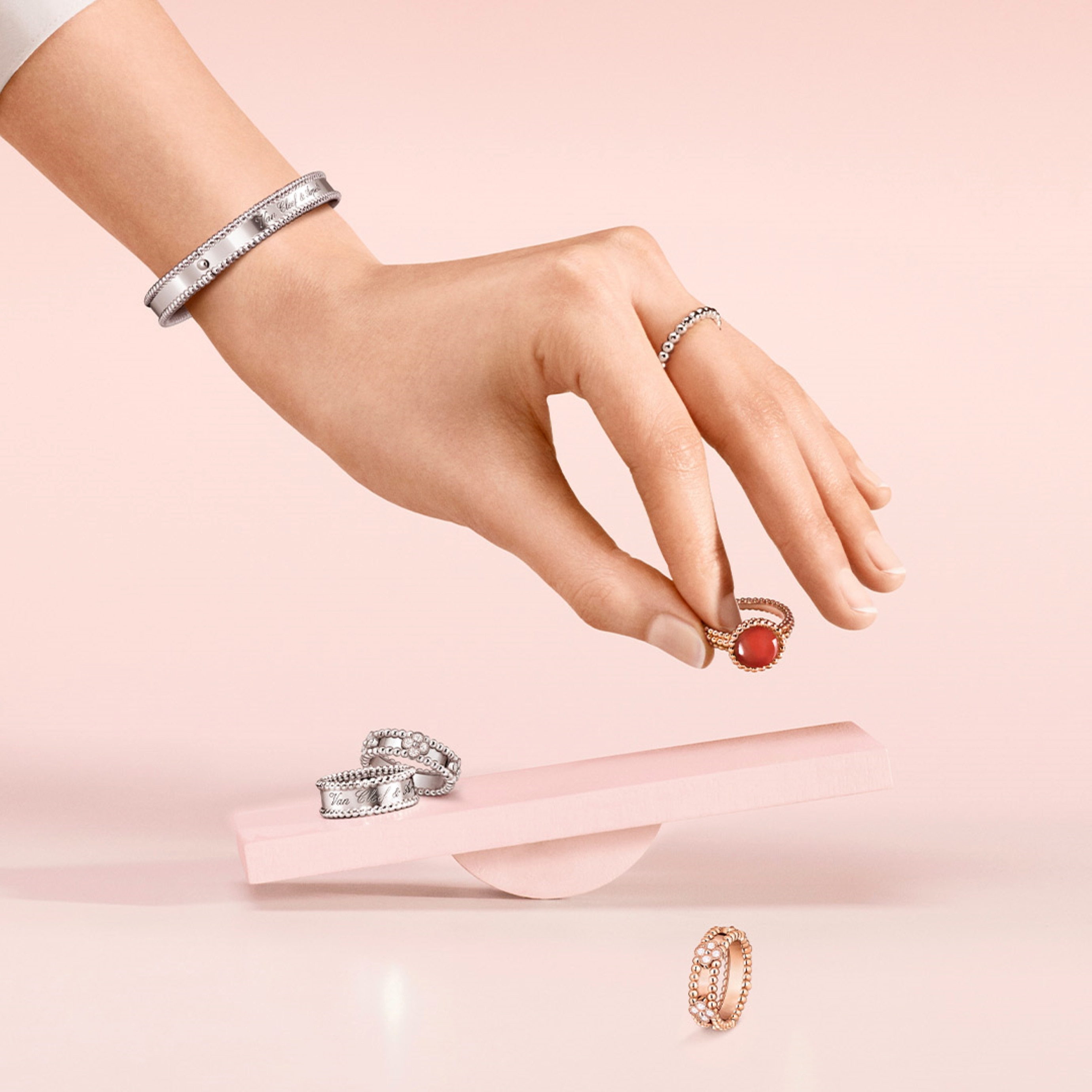 Perlée sweet clovers rings, 18K white gold, 18K rose gold, diamonds. Perlée signature bracelet and ring, 18K white gold. Perlée pearls of gold ring, small model, 18K white gold. Perlée couleurs ring, 18K rose gold, carnelian. Perlée® collection, Van Cleef & Arpels.