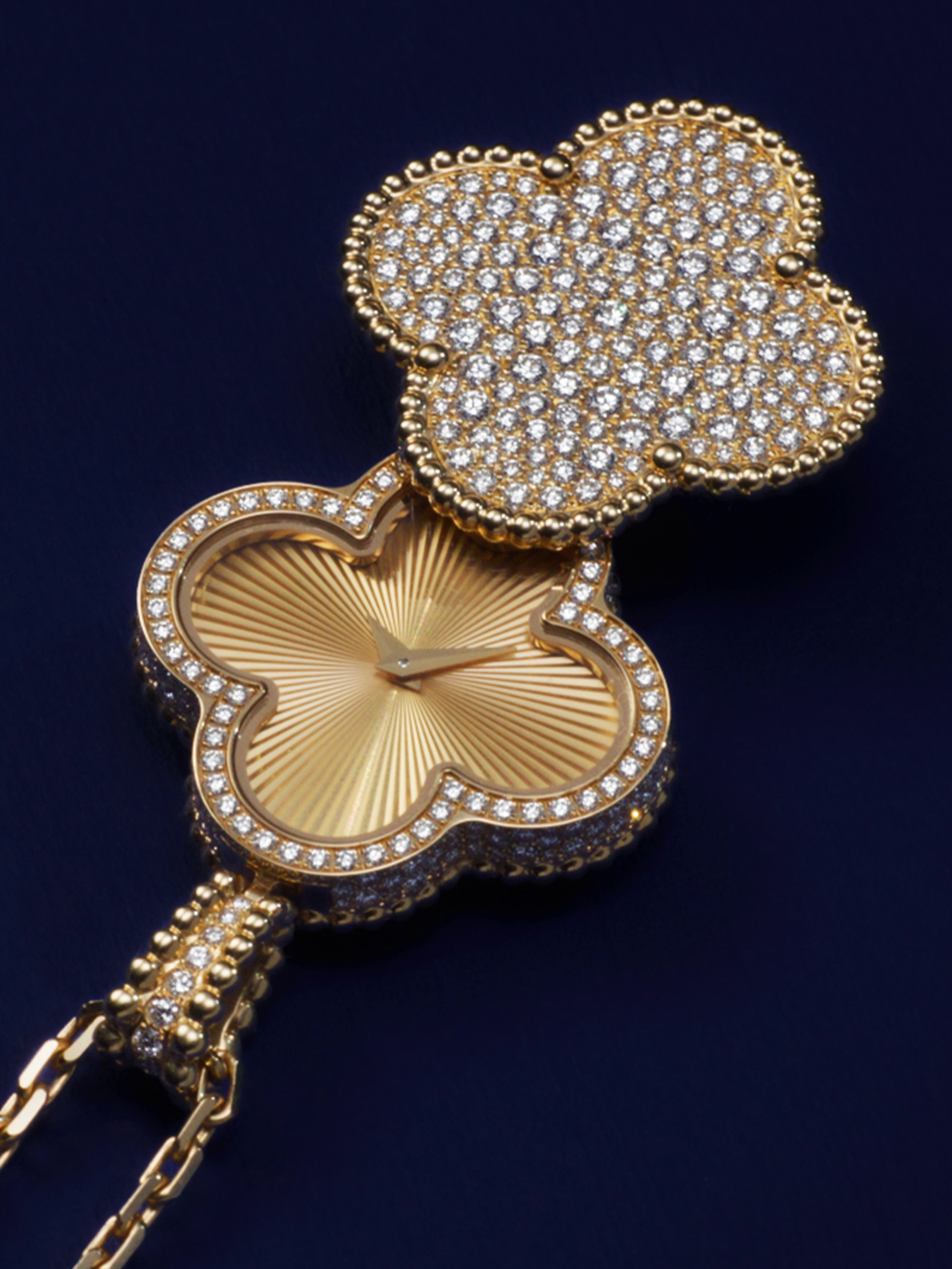 Alhambra secret pendant watch, 18K yellow gold, diamonds. Alhambra collection, Van Cleef & Arpels.